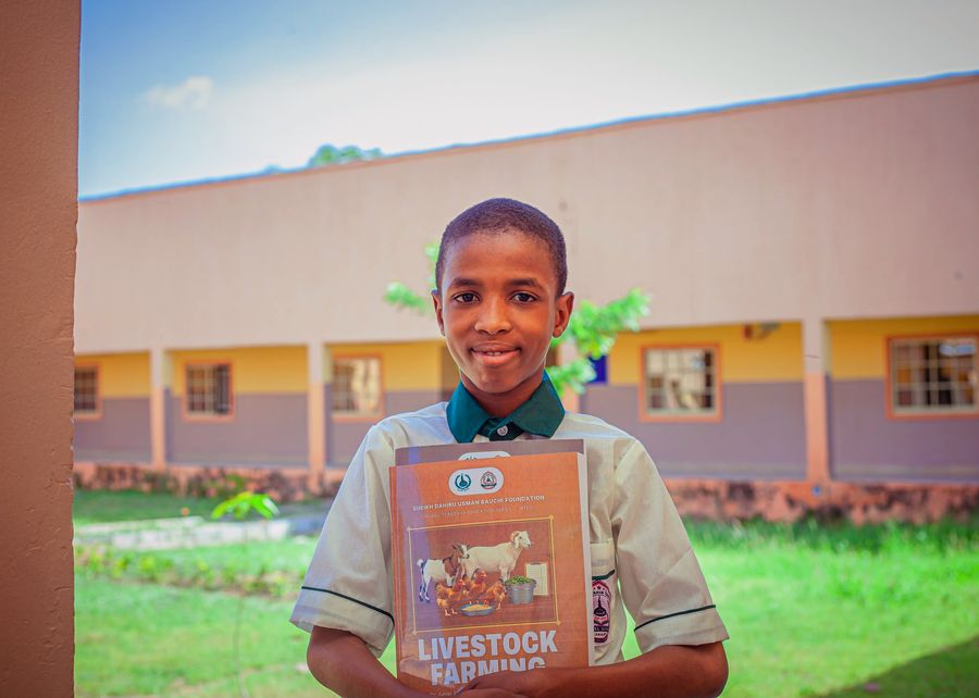 Pupil holding his Livestock Farming book